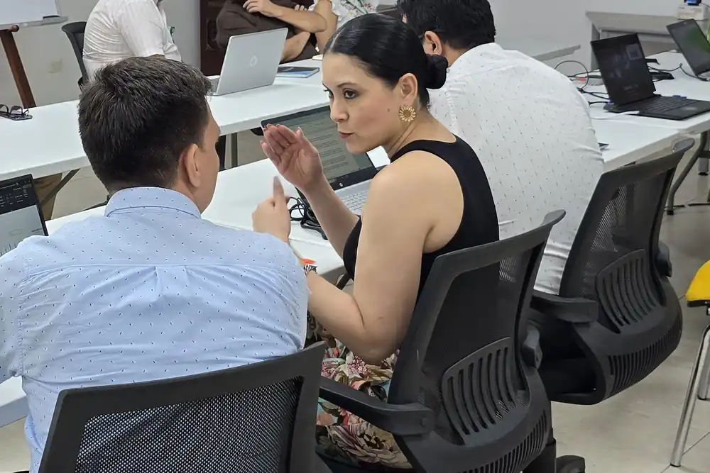 Especialistas de ColCiber trabajando junto al equipo de tecnología de un cliente frente a la consola de administración.